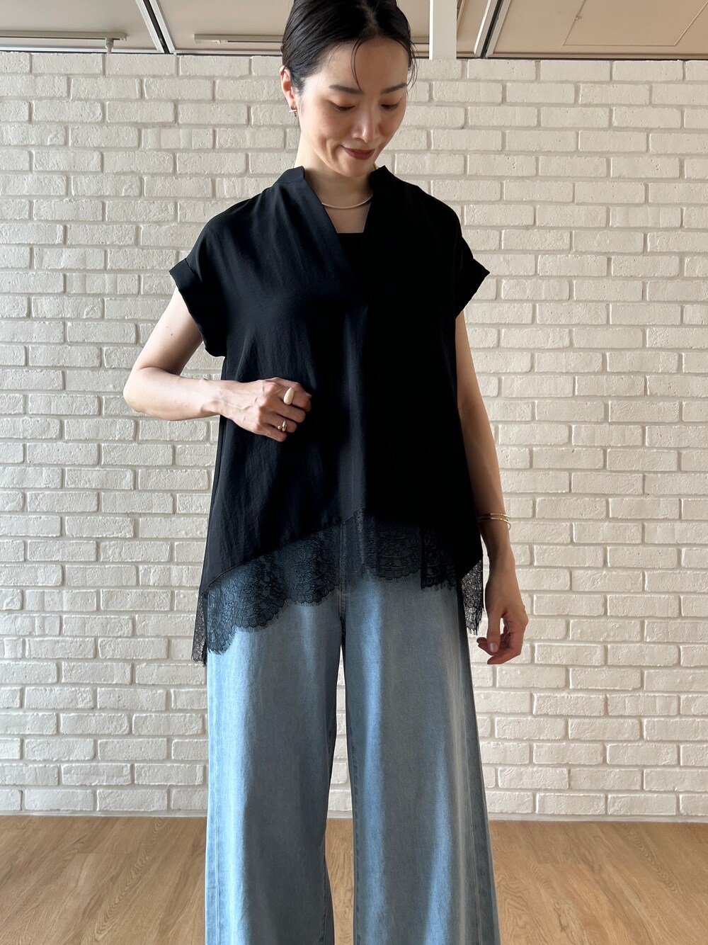 ブラック系のシャツ/ブラウス、ブルー系のデニムパンツを着用したレディースの春コーディネートの8枚目の写真