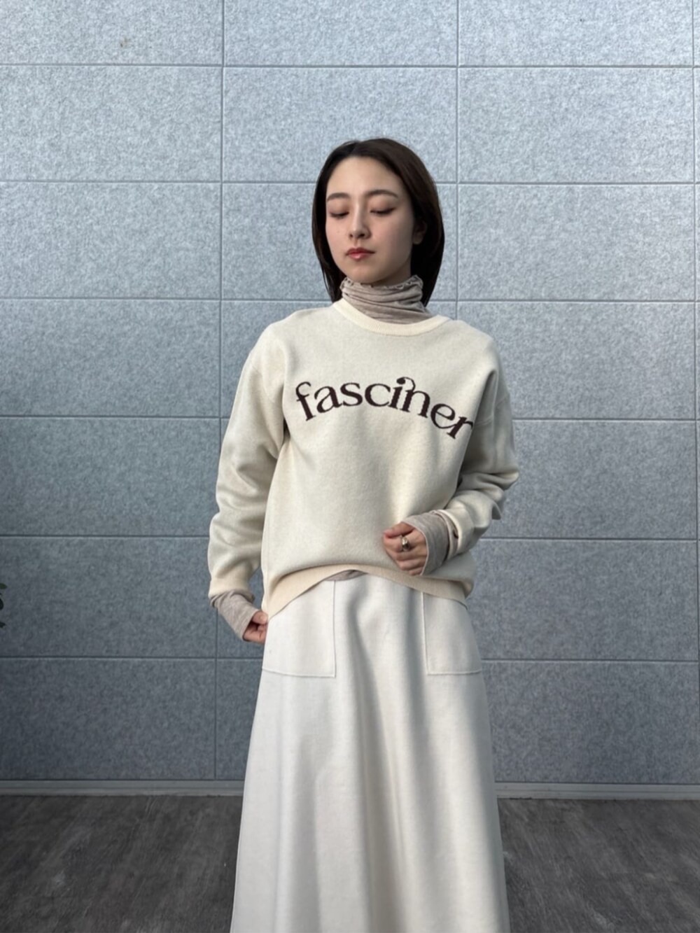 ホワイト系のスカート、ホワイト系のニット/セーター、ベージュ系のTシャツ/カットソーを着用したレディースの秋コーディネートの8枚目の写真