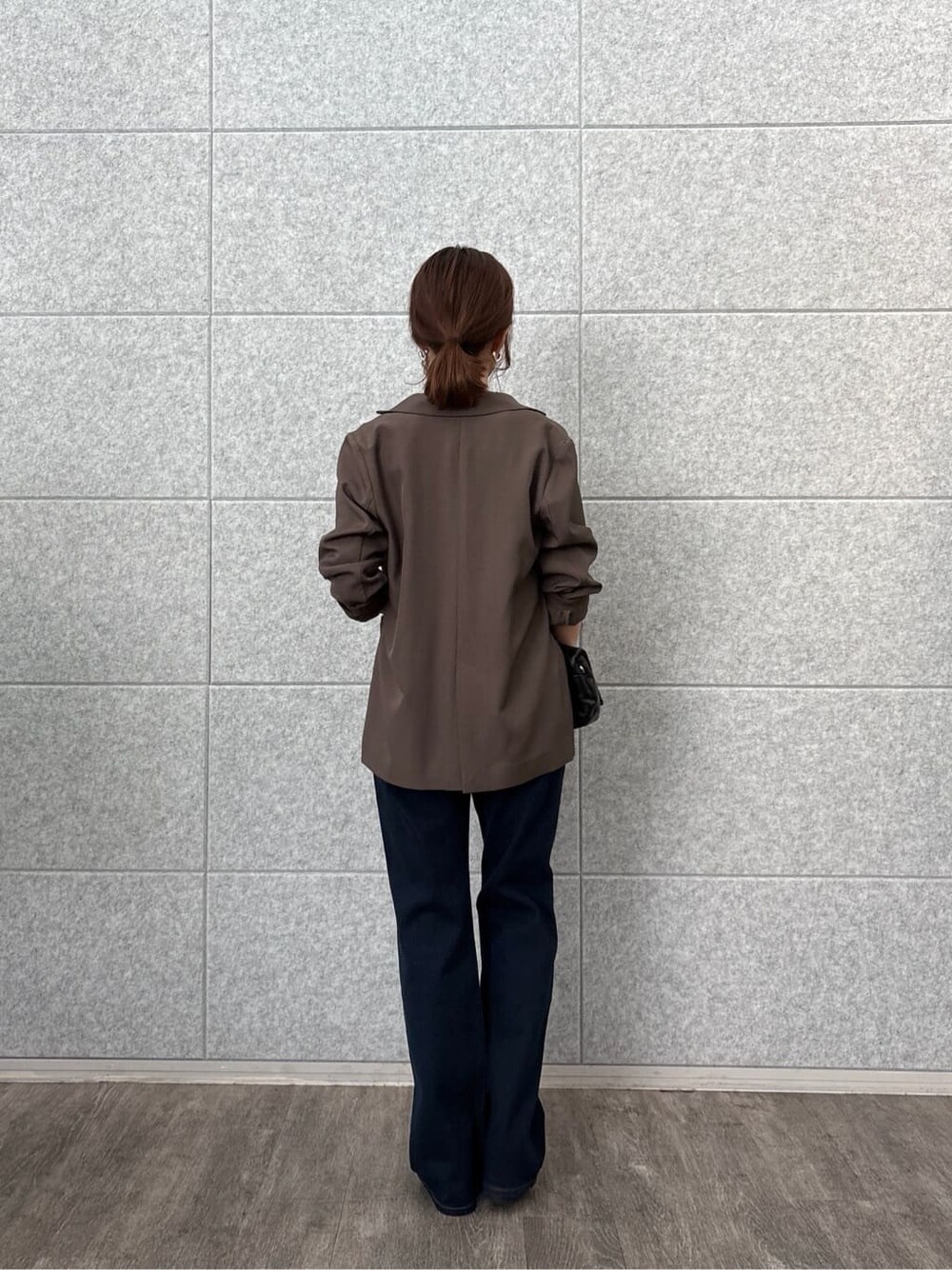 ブラウン系のテーラードジャケット、イエロー系のTシャツ/カットソー、ブルー系のデニムパンツを着用したレディースの秋コーディネートの4枚目の写真