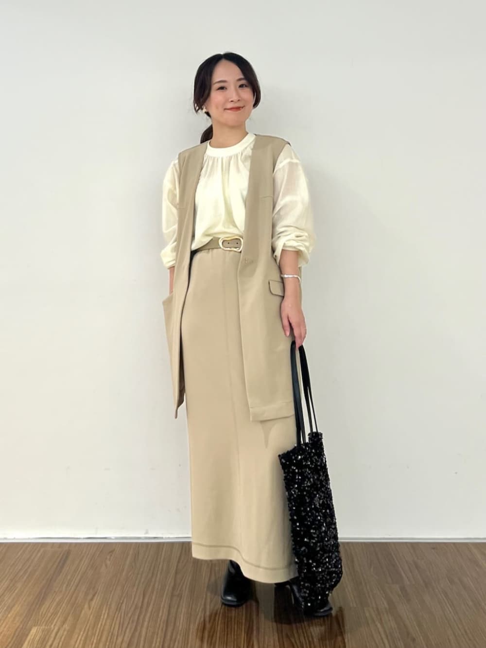 ブラウン系のスカート、ホワイト系のシャツ/ブラウス、ブラウン系のベストを着用したレディースの秋コーディネートの2枚目の写真