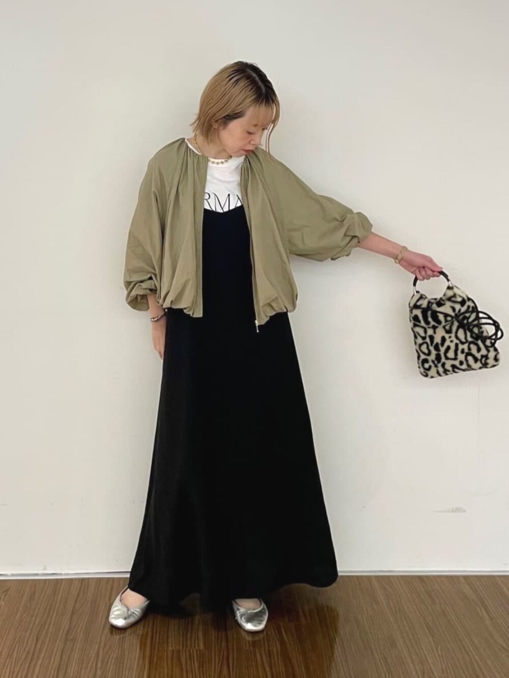 ブラック系のワンピース、ホワイト系のTシャツ/カットソー、ブラウン系のブルゾンを着用したレディースの秋コーディネートの2枚目の写真