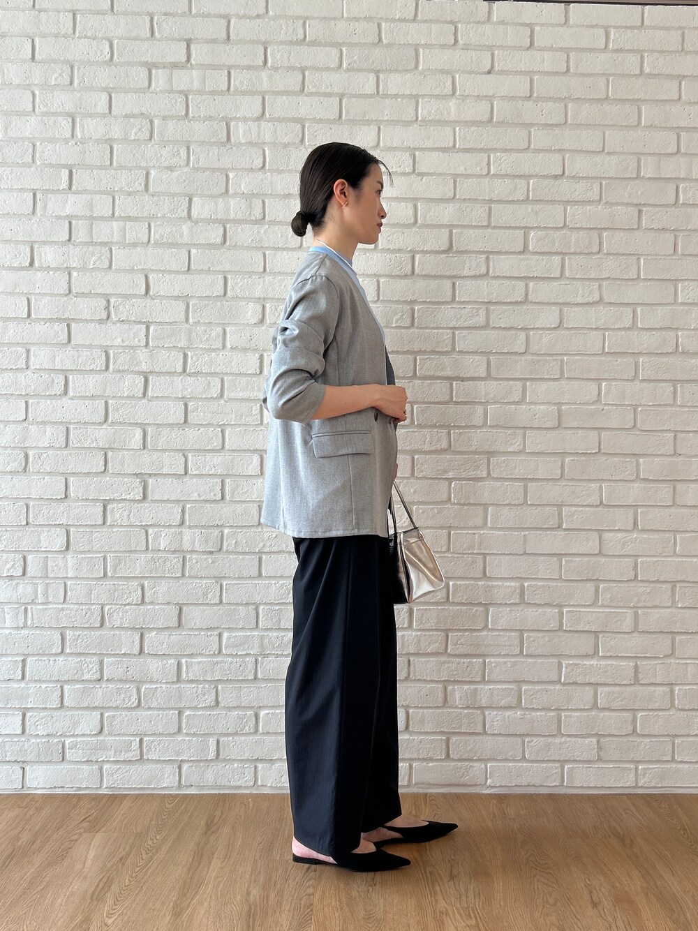ブルー系のニット/セーター、グレー系のノーカラージャケット、ブラック系のその他パンツを着用したレディースの春コーディネートの3枚目の写真