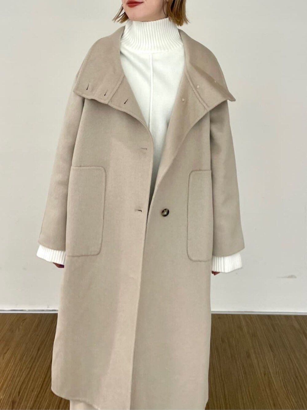 ベージュ系のスカート、ホワイト系のニット/セーター、ベージュ系のその他アウターを着用したレディースの秋コーディネートの6枚目の写真