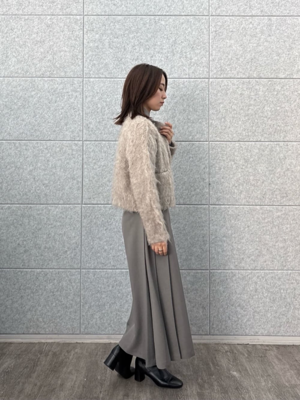 ブラウン系のニット/セーター、ベージュ系のカーディガン/ボレロ、グレー系のスカートを着用したレディースの秋コーディネートの5枚目の写真