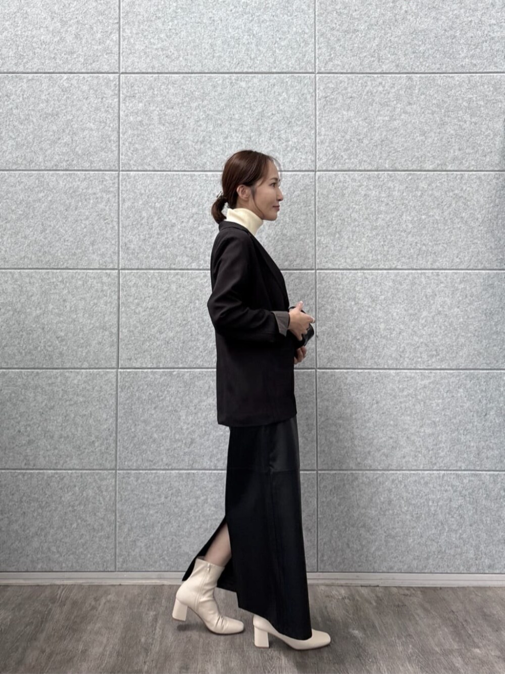 ブラック系のテーラードジャケット、ホワイト系のニット/セーターを着用したレディースの秋コーディネートの5枚目の写真