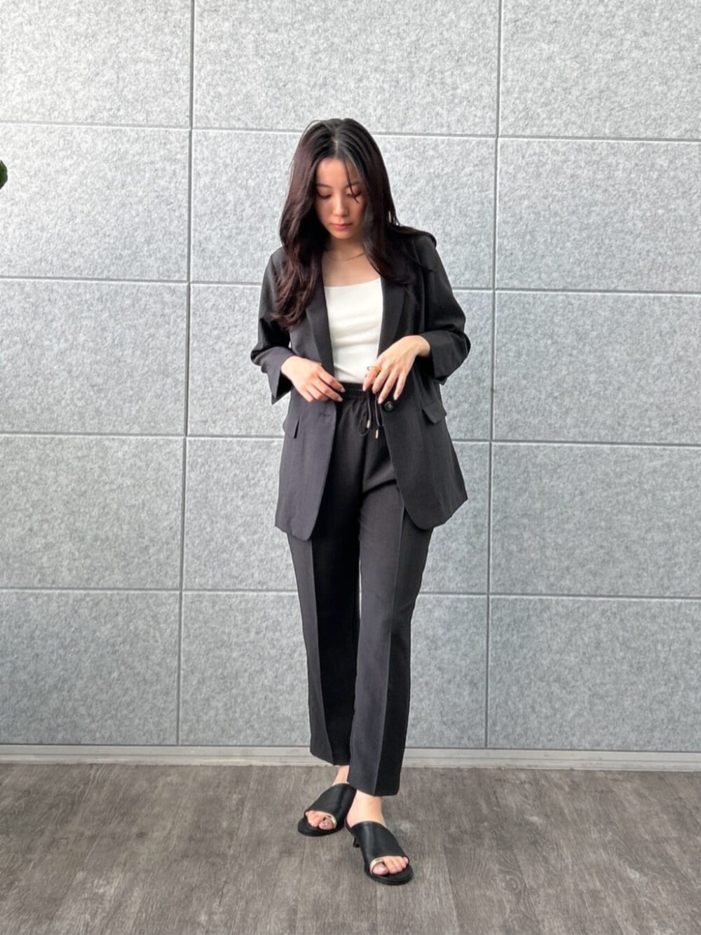 ホワイト系のタンクトップ、ブラック系のテーラードジャケット、ブラック系のその他パンツを着用したレディースの夏コーディネートの4枚目の写真