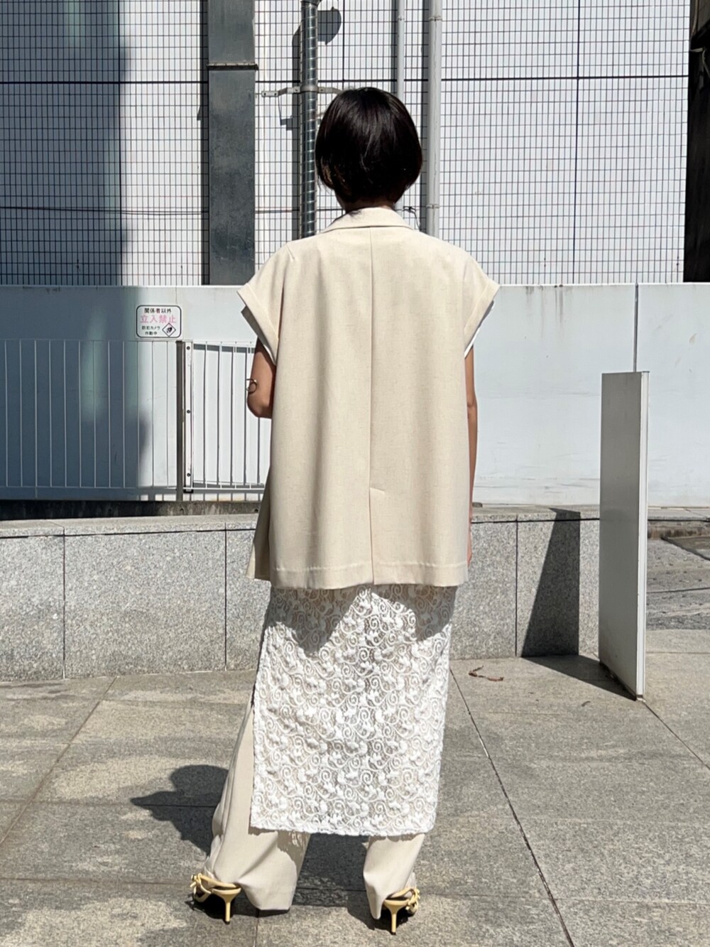 ホワイト系のタンクトップ、ホワイト系のテーラードジャケット、ホワイト系のワンピースを着用したレディースの春コーディネートの4枚目の写真