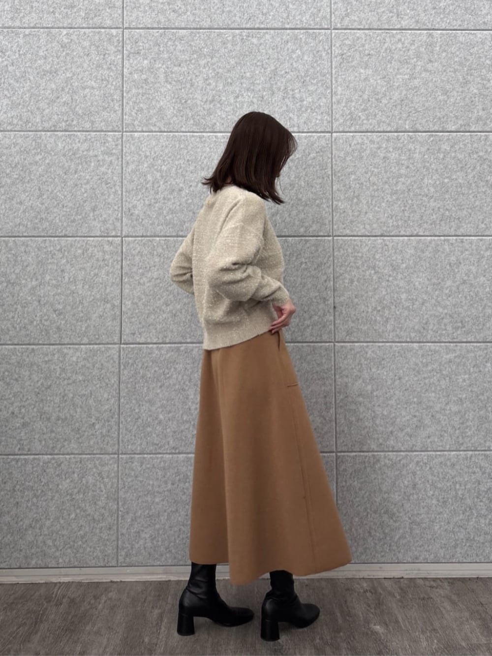 ベージュ系のニット/セーター、イエロー系のスカートを着用したレディースの秋コーディネートの3枚目の写真