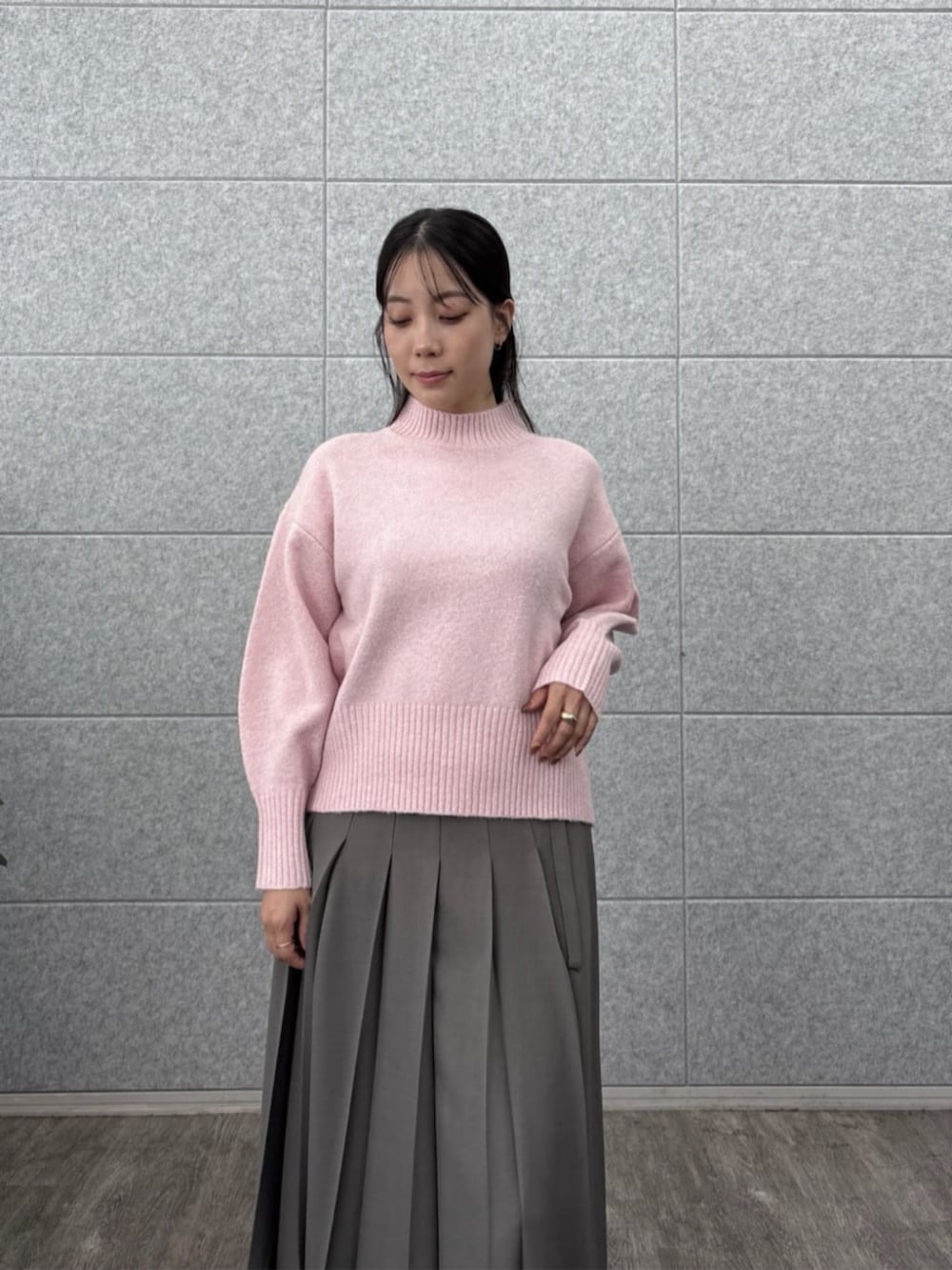 グレー系のスカート、ピンク系のニット/セーターを着用したレディースの秋コーディネートの8枚目の写真