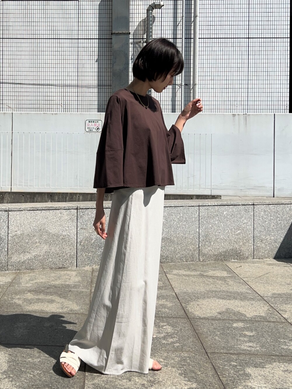 ホワイト系のスカート、ブラウン系のTシャツ/カットソーを着用したレディースの春コーディネートの6枚目の写真