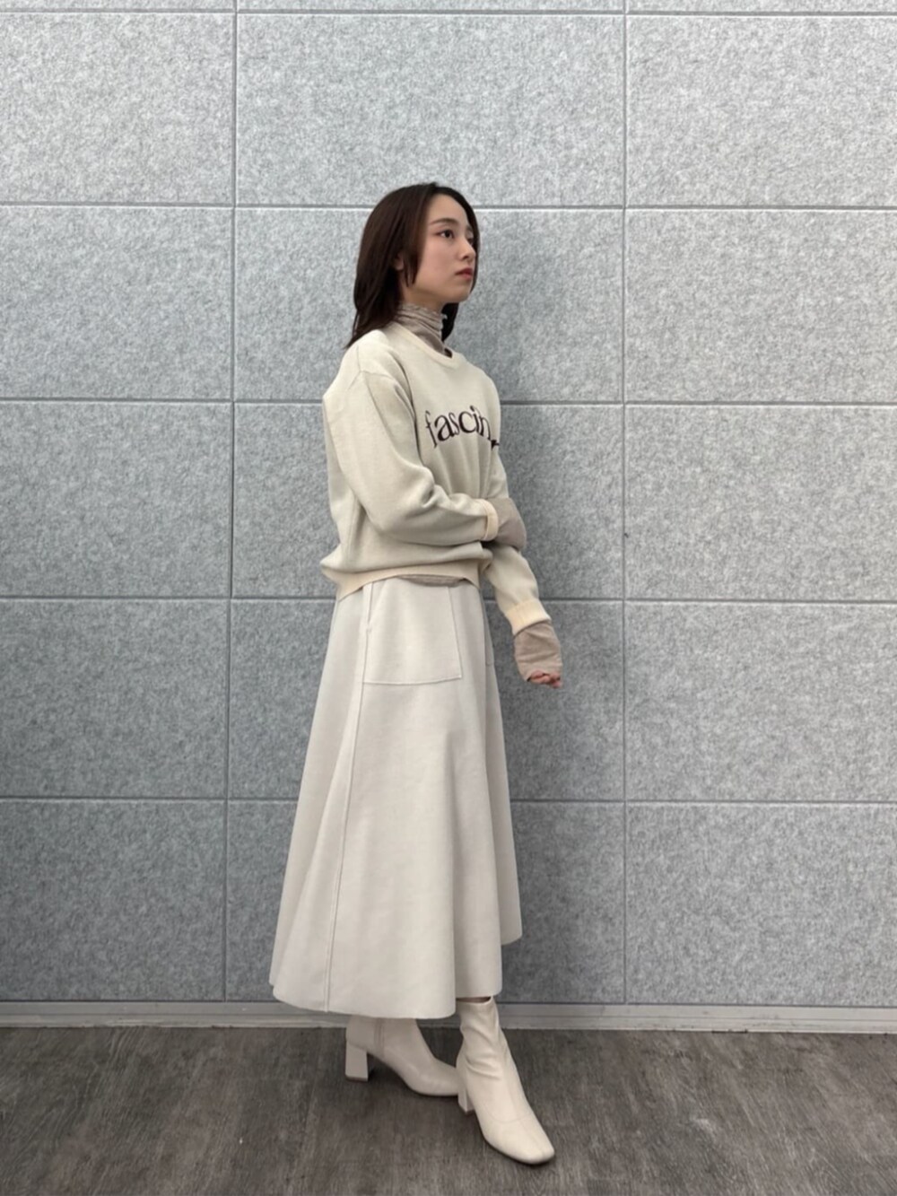 ホワイト系のスカート、ホワイト系のニット/セーター、ベージュ系のTシャツ/カットソーを着用したレディースの秋コーディネートの7枚目の写真