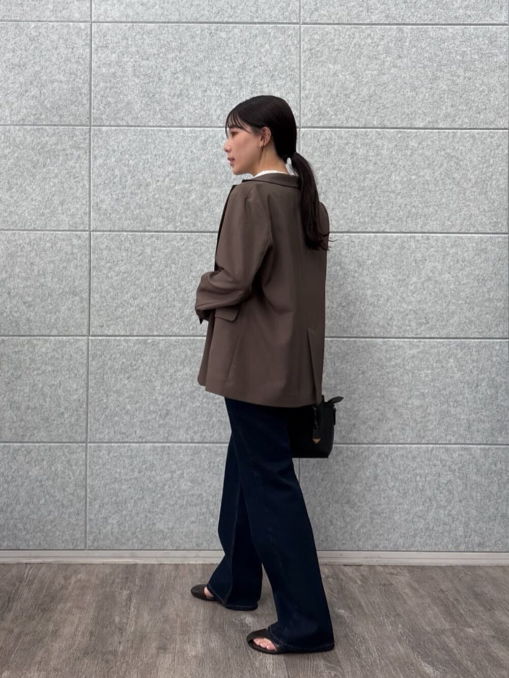 ブラウン系のテーラードジャケット、ブラック系のTシャツ/カットソー、ブルー系のデニムパンツを着用したレディースの秋コーディネートの2枚目の写真