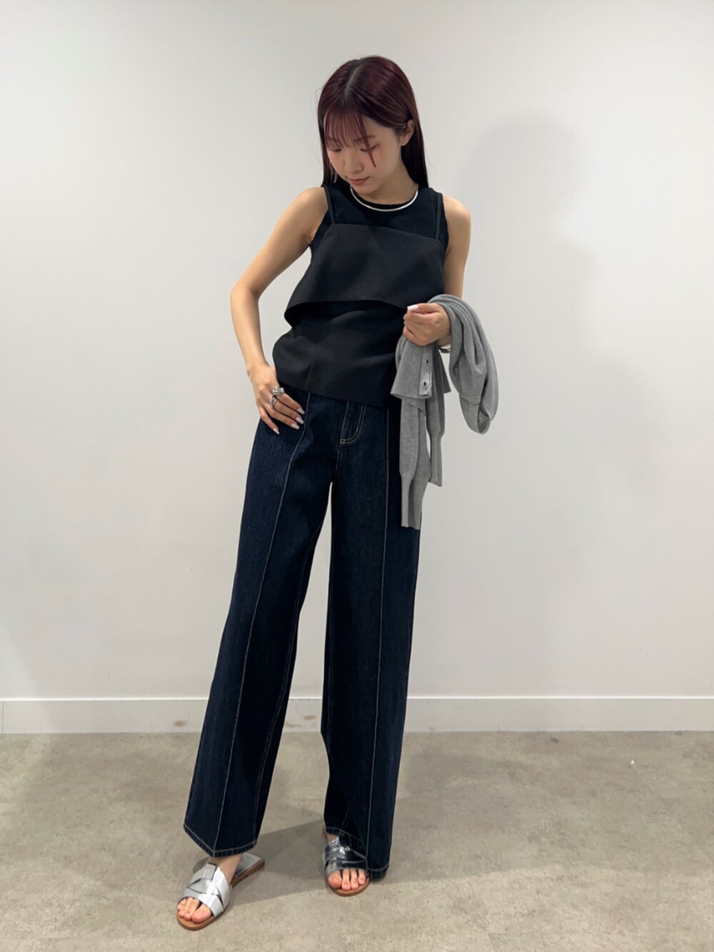 ブルー系のデニムパンツ、グレー系のカーディガン/ボレロ、ブラック系のシャツ/ブラウスを着用したレディースの春コーディネートの2枚目の写真