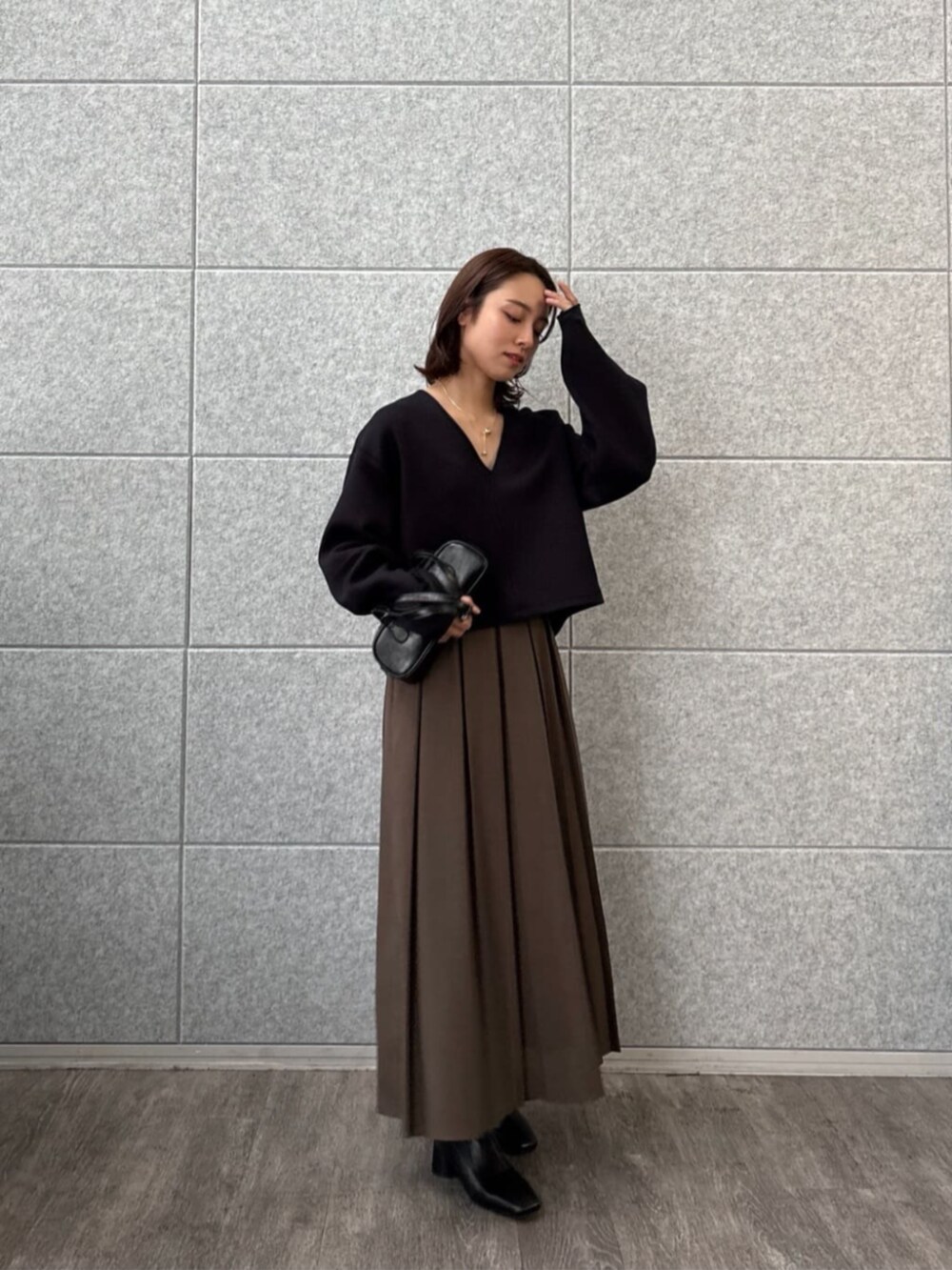 ブラウン系のスカート、ブラック系のTシャツ/カットソーを着用したレディースの秋コーディネートの5枚目の写真