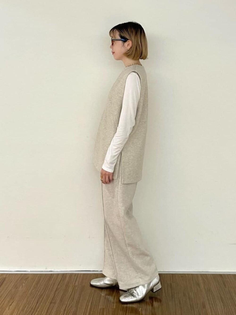 ホワイト系のTシャツ/カットソー、ベージュ系のベスト、ベージュ系のその他パンツを着用したレディースの秋コーディネートの6枚目の写真