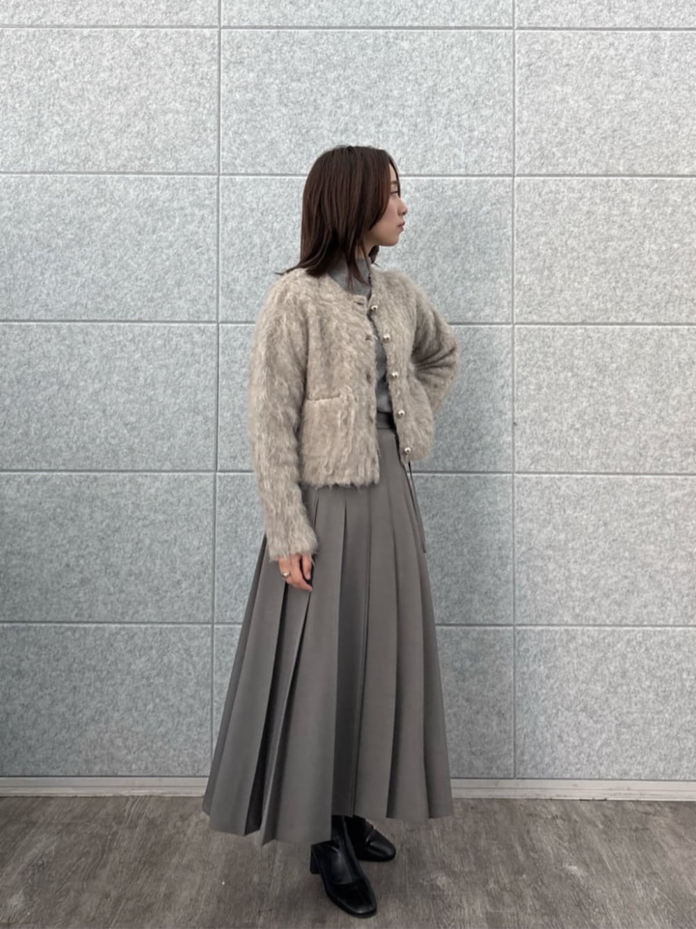 ブラウン系のニット/セーター、ベージュ系のカーディガン/ボレロ、グレー系のスカートを着用したレディースの秋コーディネートの6枚目の写真