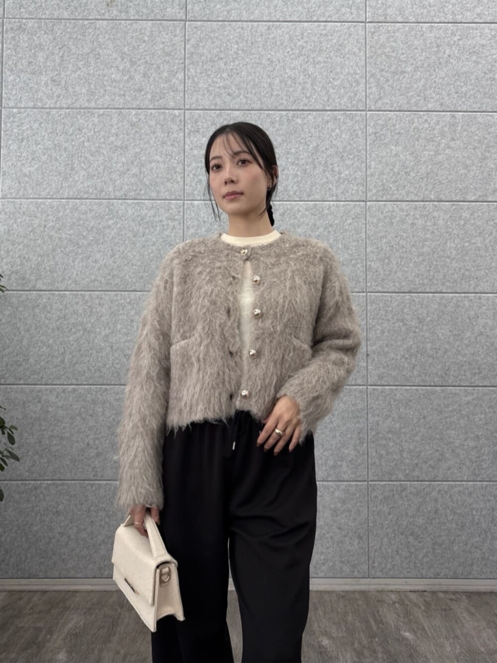 ブラック系のその他パンツ、ホワイト系のニット/セーター、ベージュ系のカーディガン/ボレロを着用したレディースの秋コーディネートの6枚目の写真