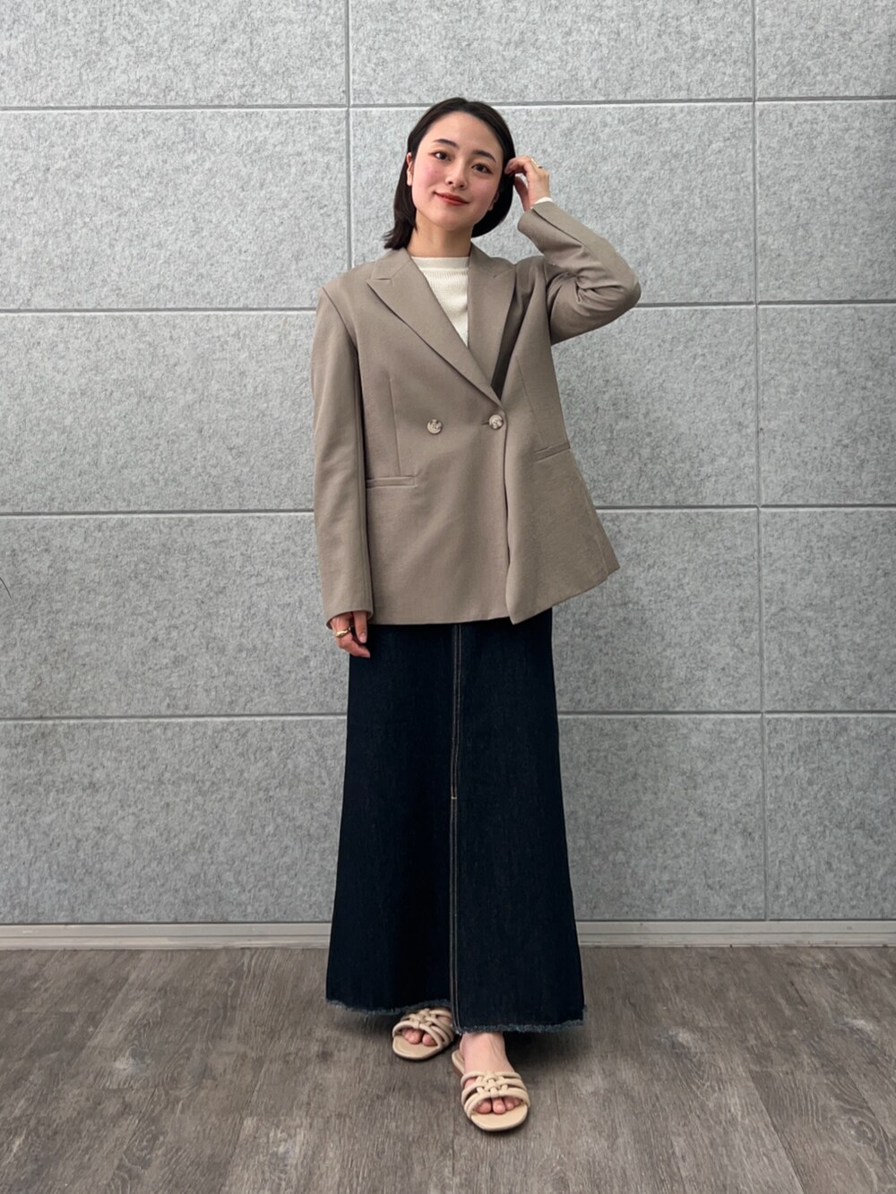 ブラウン系のテーラードジャケット、ブルー系のデニムスカート、ホワイト系のTシャツ/カットソーを着用したレディースの春コーディネートの3枚目の写真