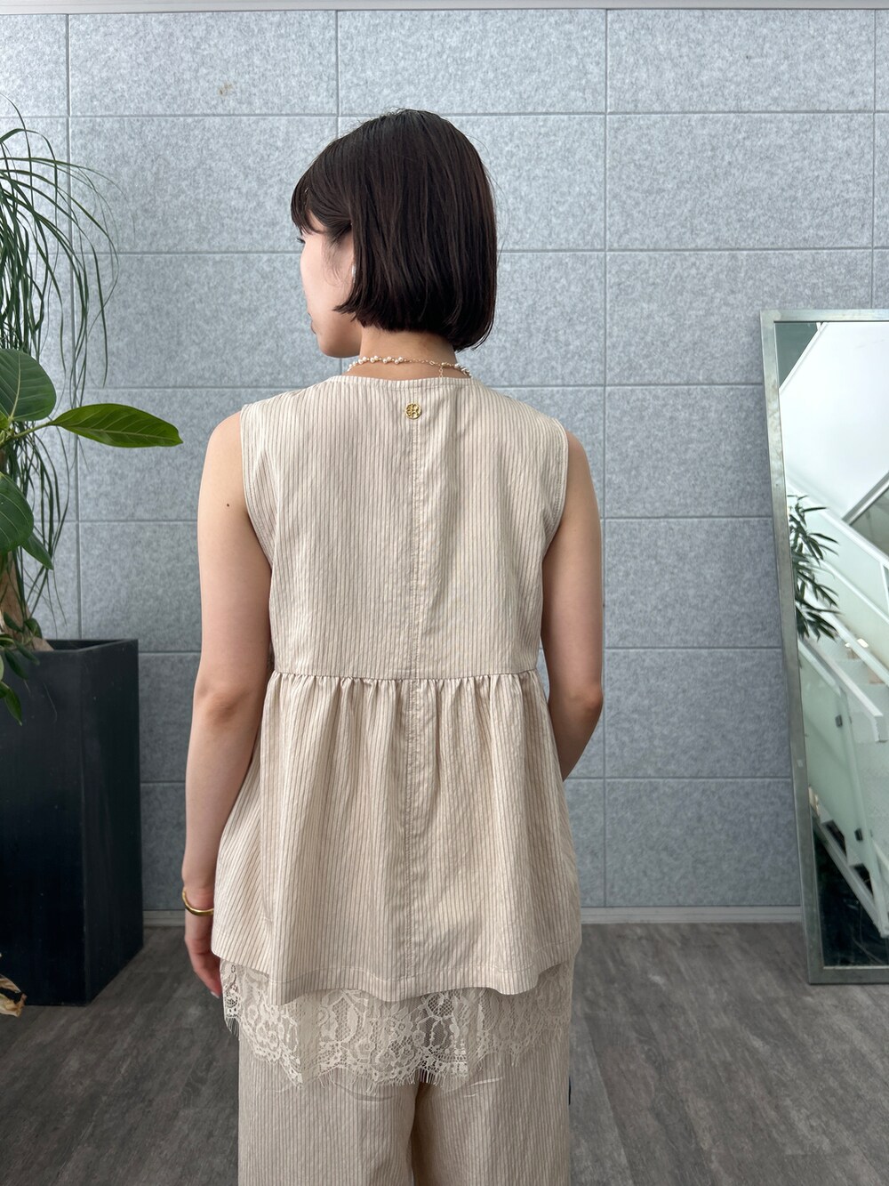 ベージュ系のシャツ/ブラウス、ホワイト系のタンクトップ、ベージュ系のその他パンツを着用したレディースの夏コーディネートの7枚目の写真