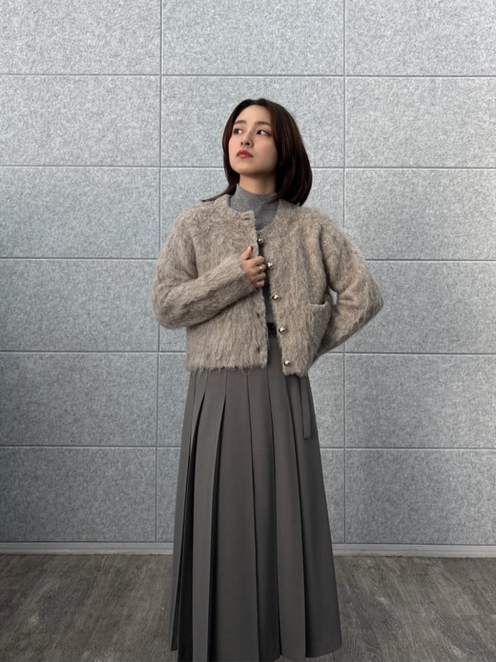 ブラウン系のニット/セーター、ベージュ系のカーディガン/ボレロ、グレー系のスカートを着用したレディースの秋コーディネートの7枚目の写真