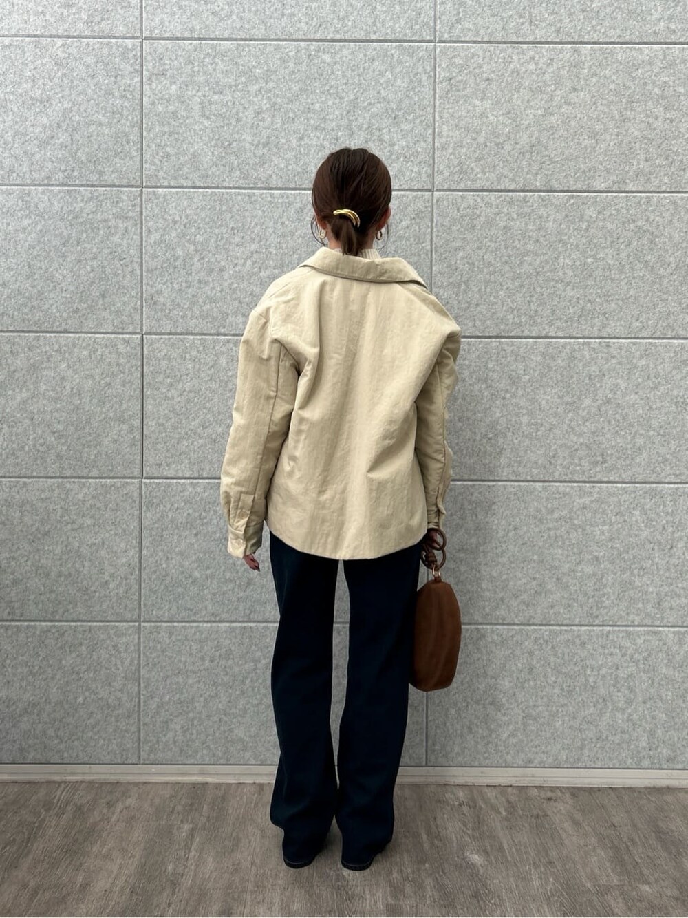 ベージュ系のブルゾン、ホワイト系のニット/セーター、ブルー系のデニムパンツを着用したレディースの冬コーディネートの7枚目の写真