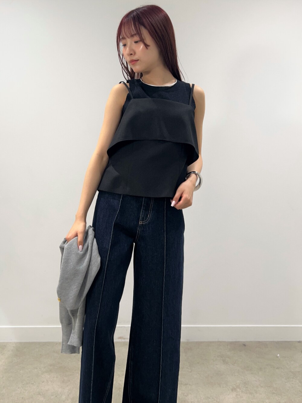 ブルー系のデニムパンツ、グレー系のカーディガン/ボレロ、ブラック系のシャツ/ブラウスを着用したレディースの春コーディネートの3枚目の写真