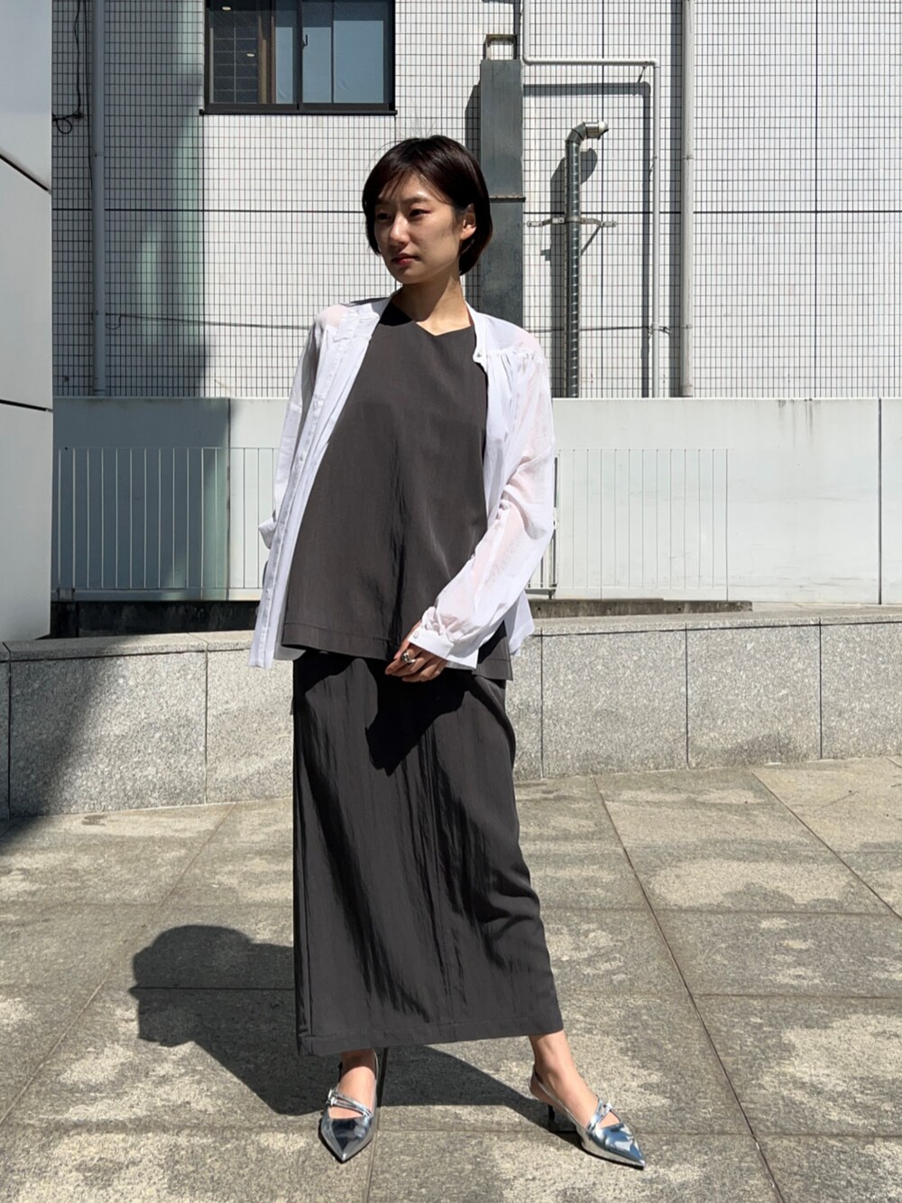 ホワイト系のシャツ/ブラウス、グレー系のシャツ/ブラウス、グレー系のスカートを着用したレディースの春コーディネートの2枚目の写真