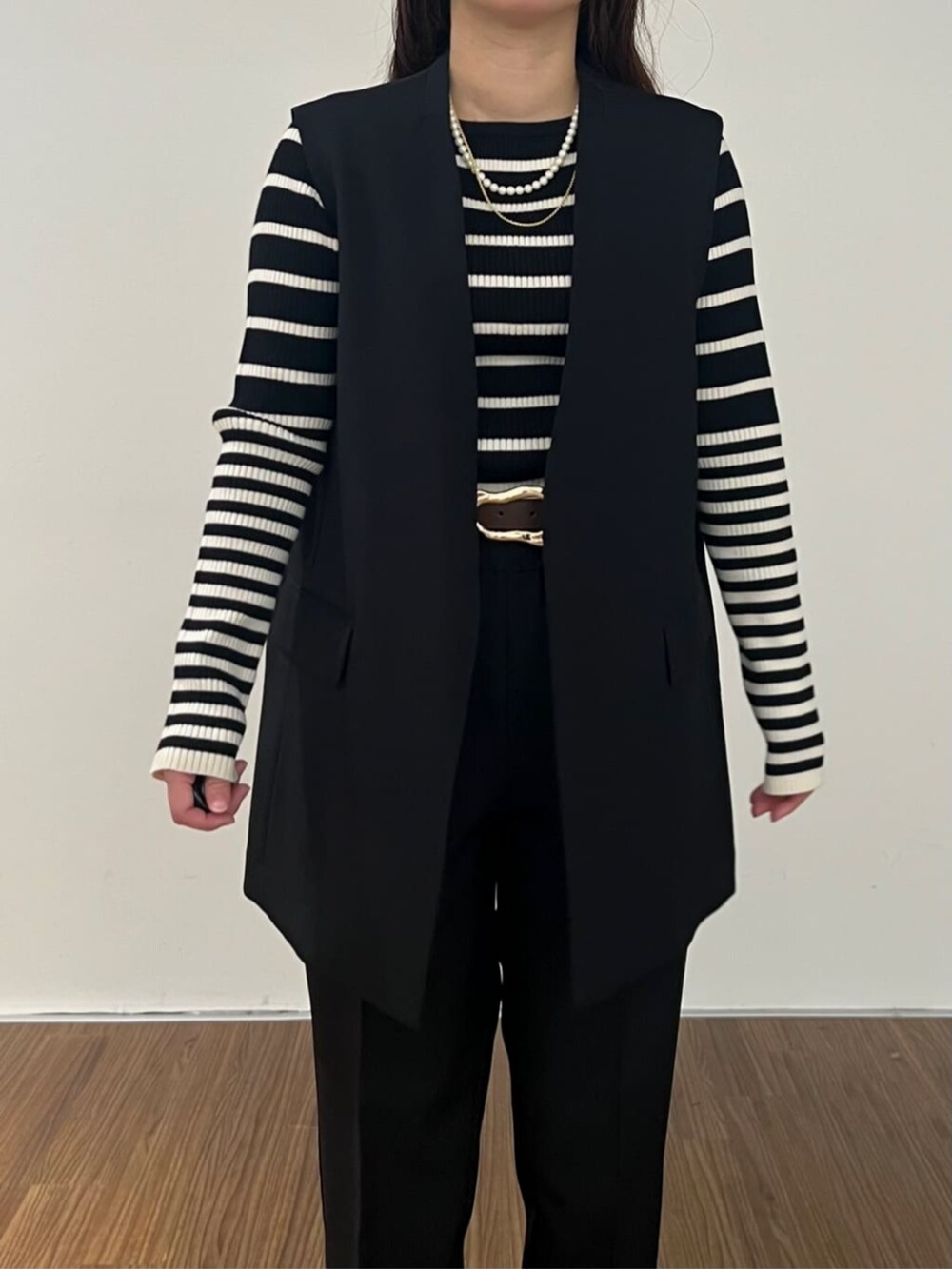 ブラック系のニット/セーター、ブラック系のその他パンツ、ブラック系のベストを着用したレディースの秋コーディネートの5枚目の写真