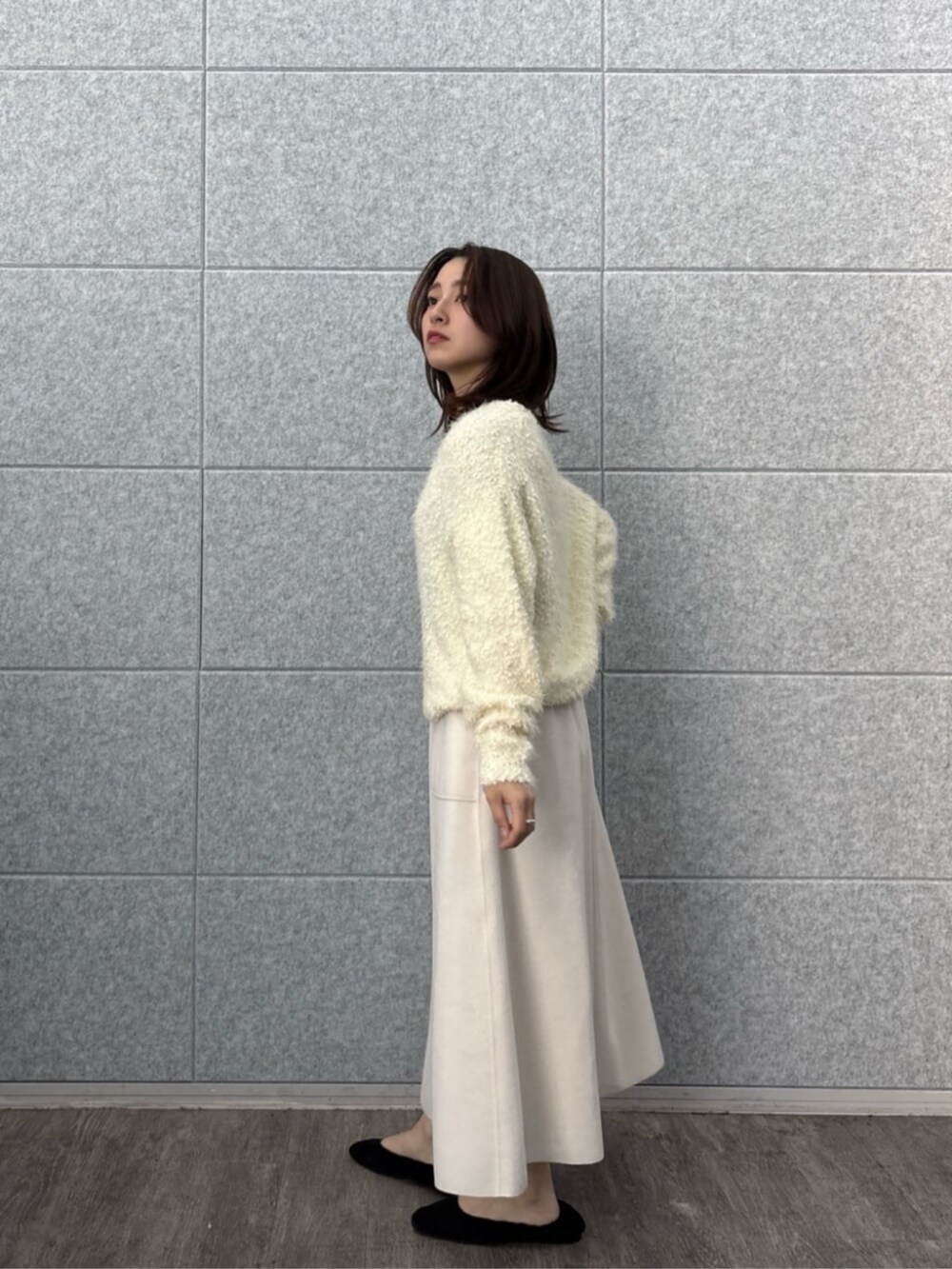 ホワイト系のニット/セーター、ホワイト系のスカートを着用したレディースの冬コーディネートの3枚目の写真