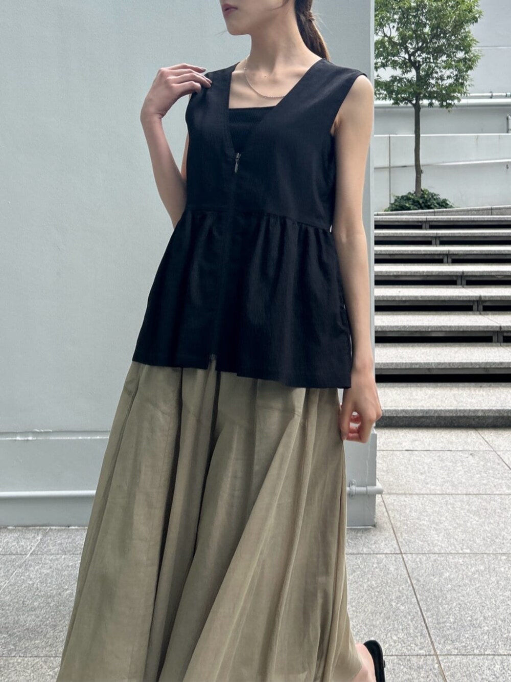 グリーン系のスカート、ブラック系のタンクトップ、ブラック系のシャツ/ブラウスを着用したレディースの夏コーディネートの4枚目の写真