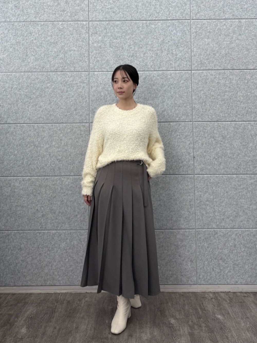 ホワイト系のニット/セーター、グレー系のスカートを着用したレディースの秋コーディネートの5枚目の写真