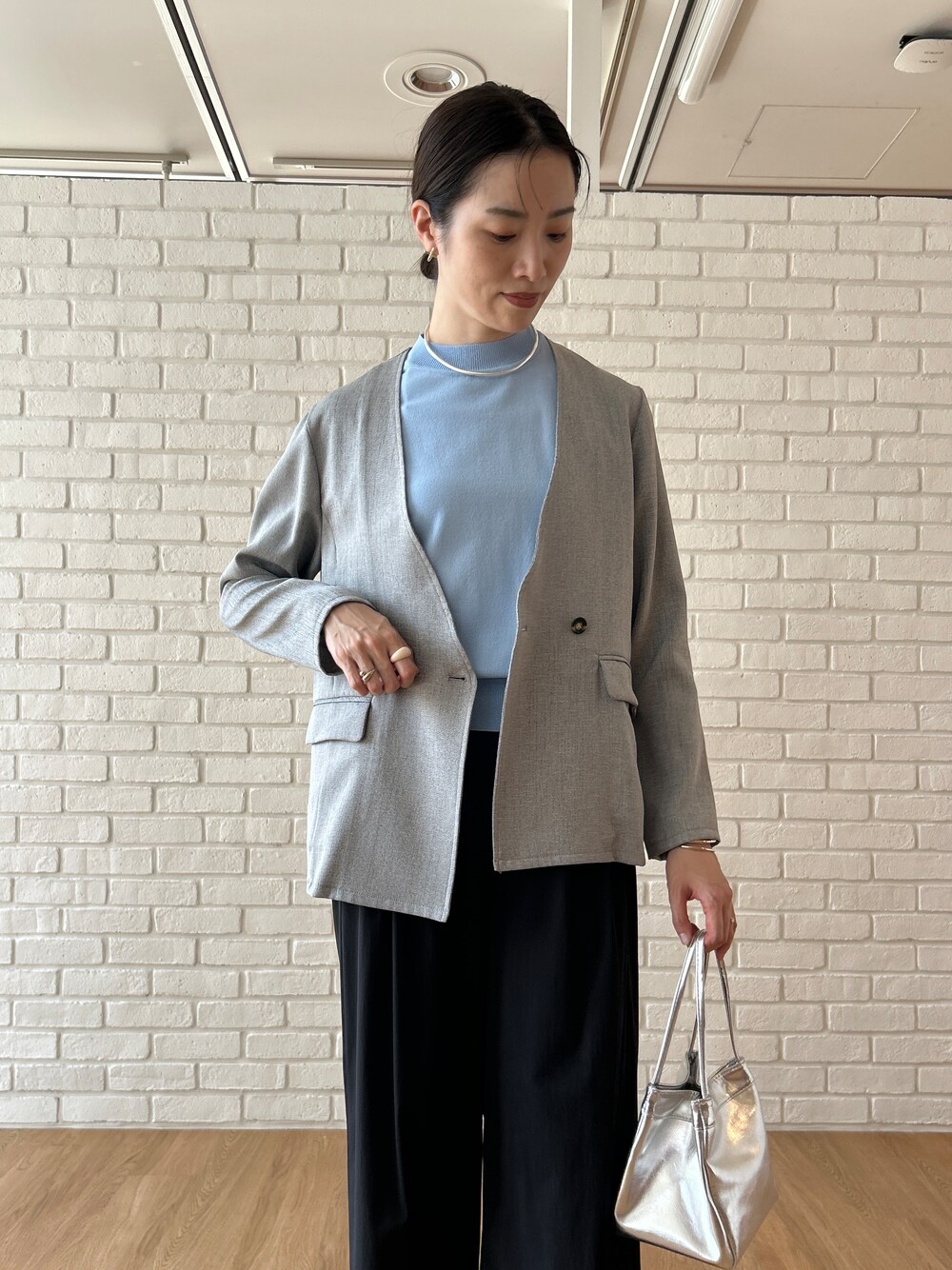 ブルー系のニット/セーター、グレー系のノーカラージャケット、ブラック系のその他パンツを着用したレディースの春コーディネートの7枚目の写真