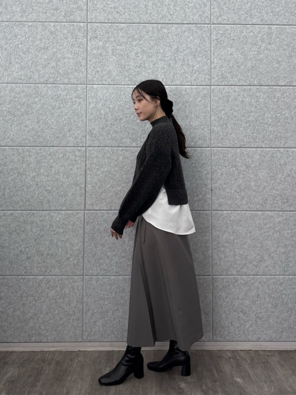 グレー系のスカート、グレー系のニット/セーターを着用したレディースの秋コーディネートの3枚目の写真