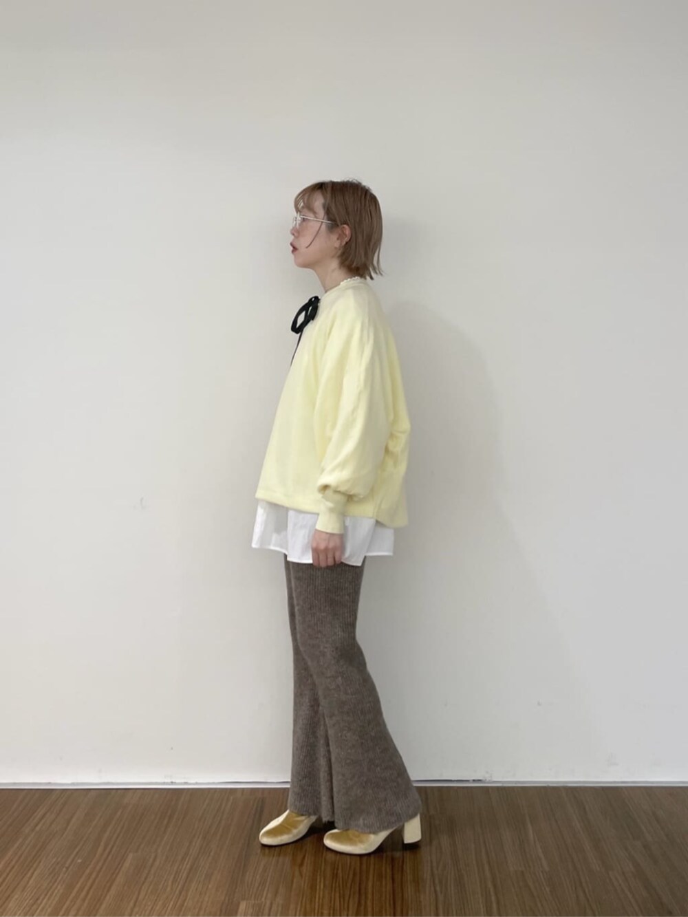 ホワイト系のシャツ/ブラウス、ブラウン系のその他パンツ、イエロー系のニット/セーターを着用したレディースの秋コーディネートの3枚目の写真