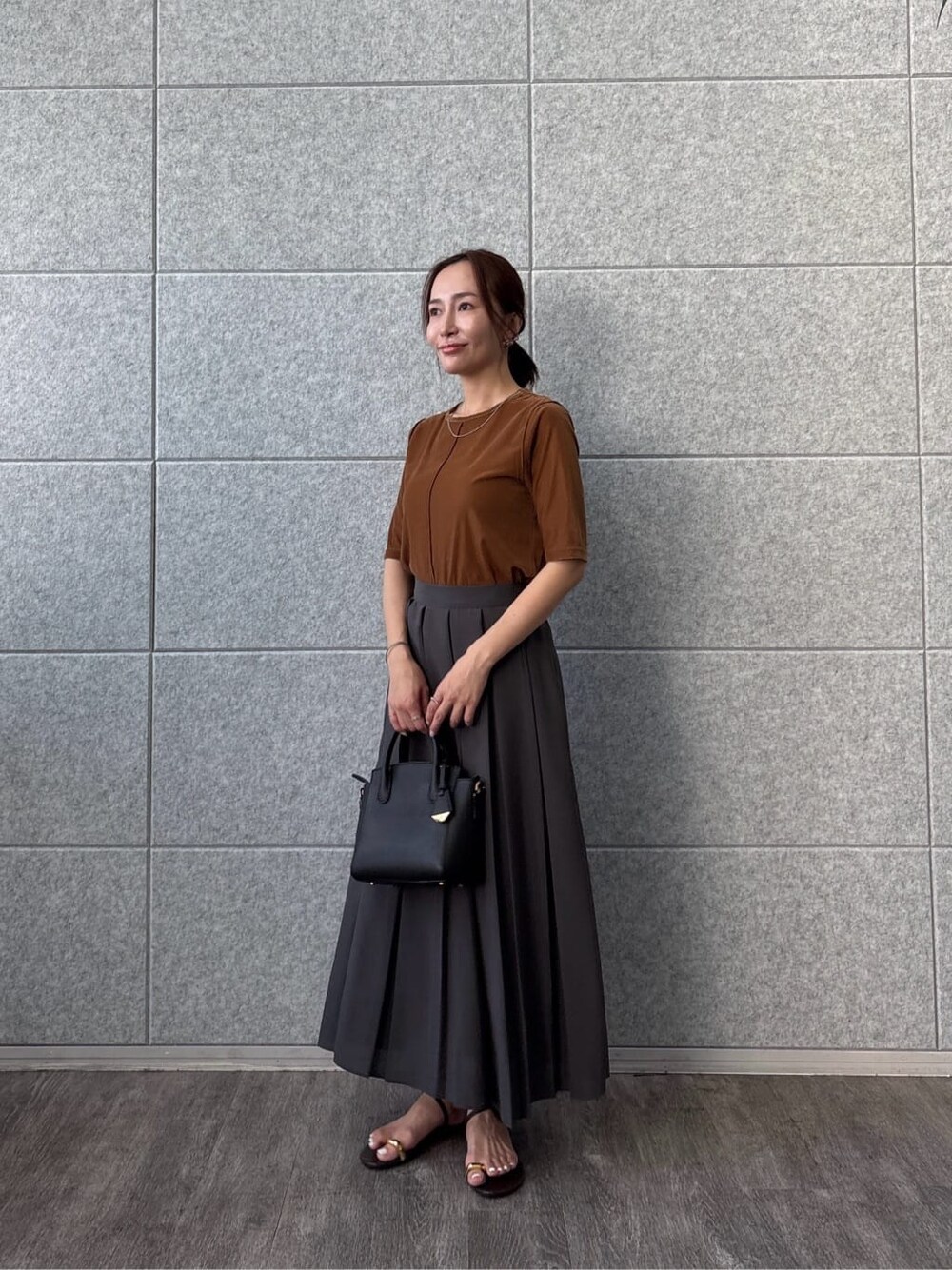 イエロー系のTシャツ/カットソー、グレー系のスカートを着用したレディースの夏コーディネートの2枚目の写真