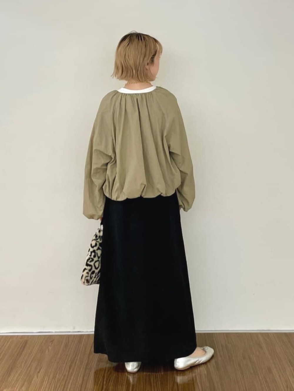 ブラック系のワンピース、ホワイト系のTシャツ/カットソー、ブラウン系のブルゾンを着用したレディースの秋コーディネートの4枚目の写真