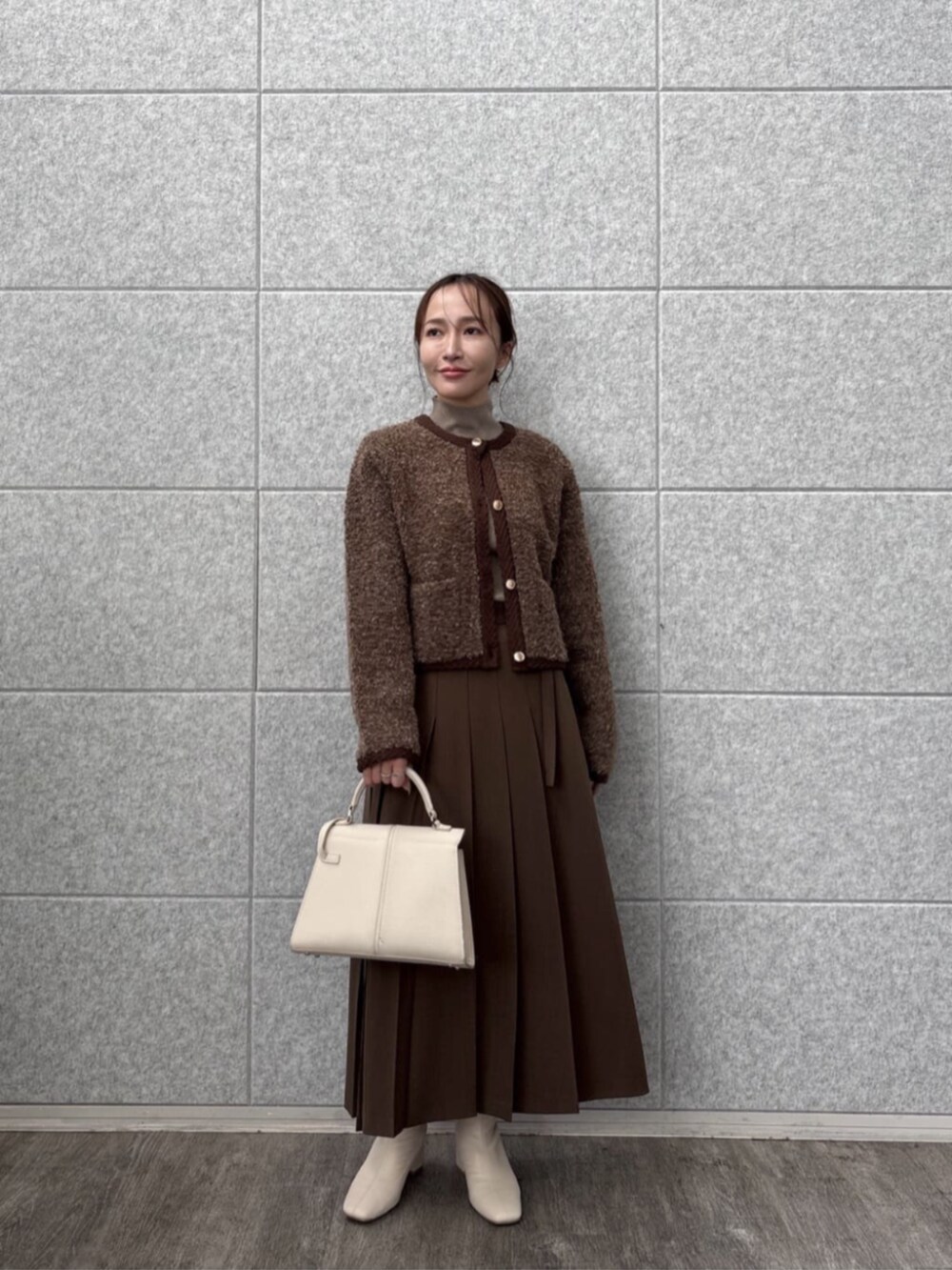 ブラウン系のスカート、ブラウン系のカーディガン/ボレロ、ブラウン系のニット/セーターを着用したレディースの秋コーディネートの4枚目の写真