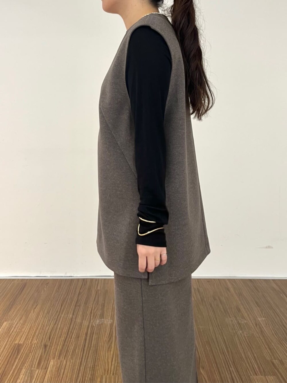 ブラウン系のベスト、ブラウン系のスカート、ブラック系のTシャツ/カットソーを着用したレディースの秋コーディネートの7枚目の写真