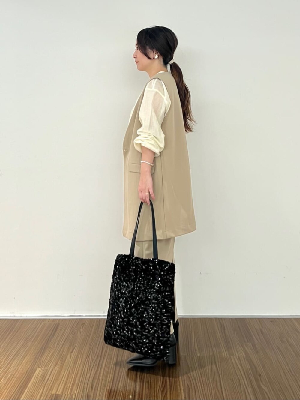 ブラウン系のスカート、ホワイト系のシャツ/ブラウス、ブラウン系のベストを着用したレディースの秋コーディネートの4枚目の写真