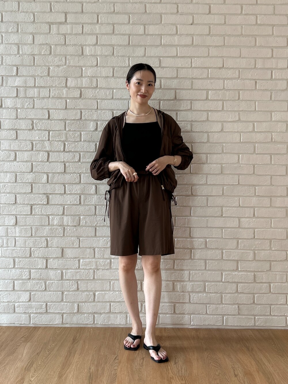ブラウン系のブルゾン、ブラック系のタンクトップ、ブラウン系のその他パンツを着用したレディースの春コーディネートの7枚目の写真