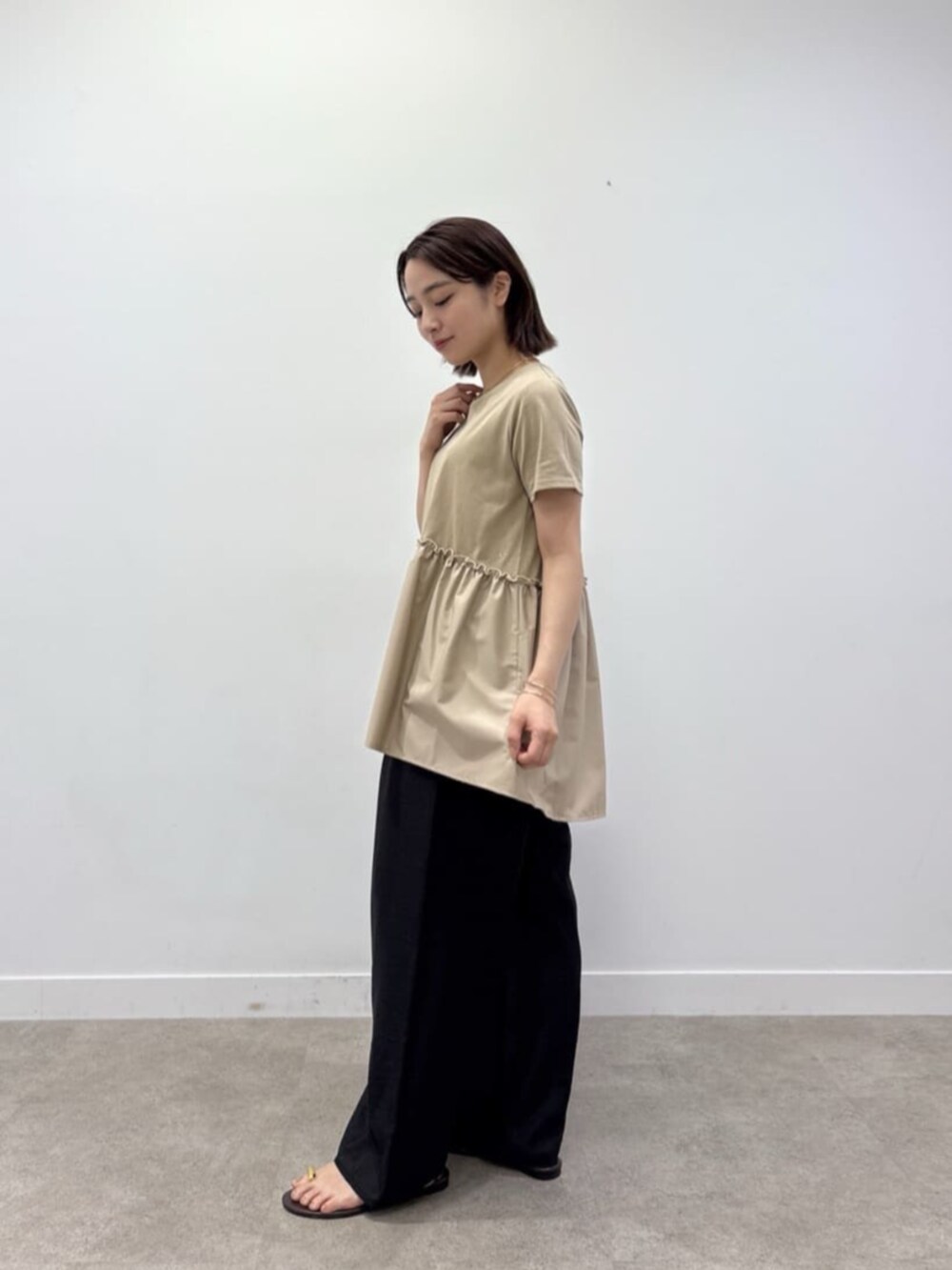ブラック系のその他パンツ、ベージュ系のTシャツ/カットソーを着用したレディースの夏コーディネートの4枚目の写真