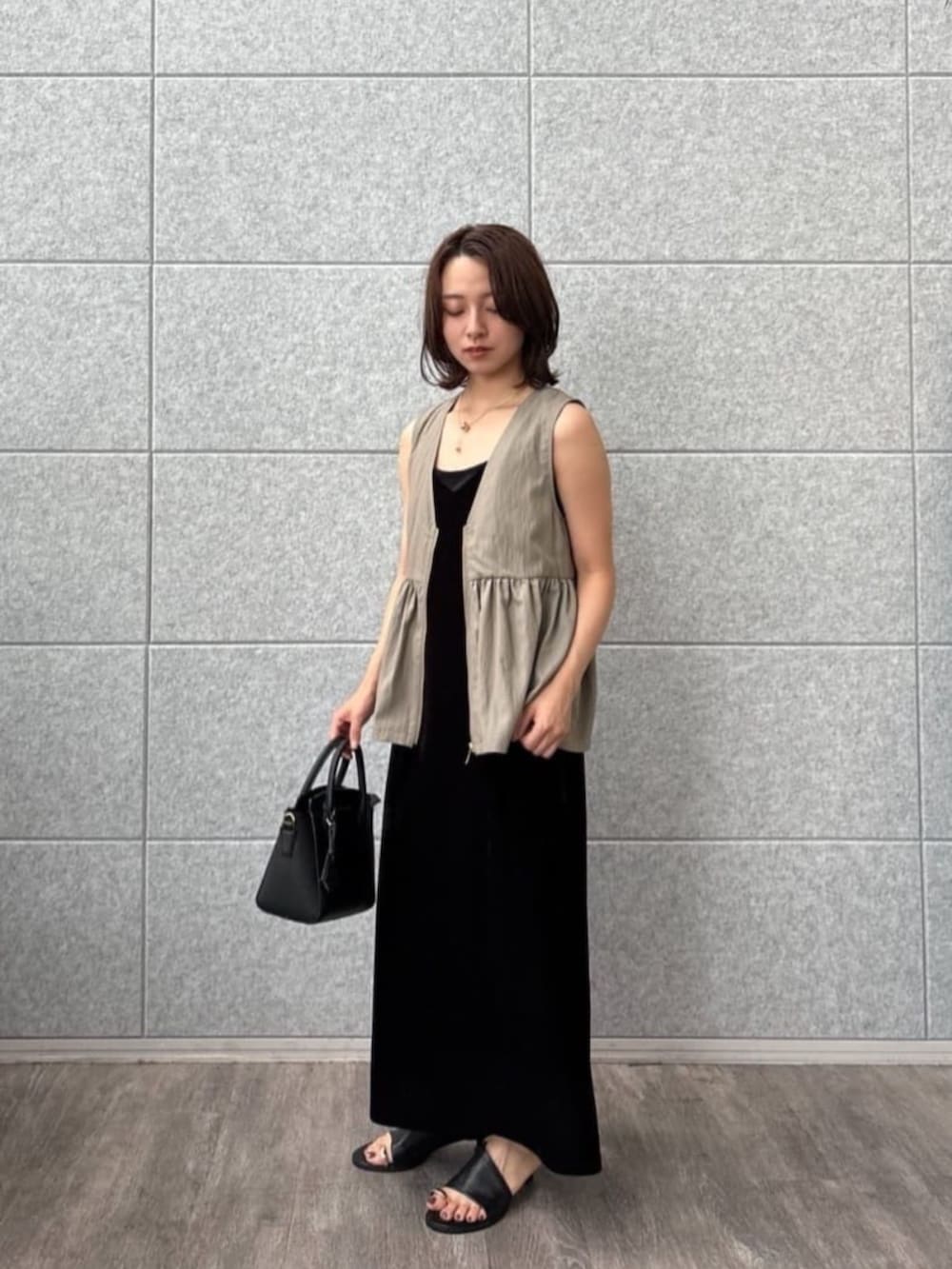 グリーン系のベストを着用したレディースの秋コーディネートの4枚目の写真