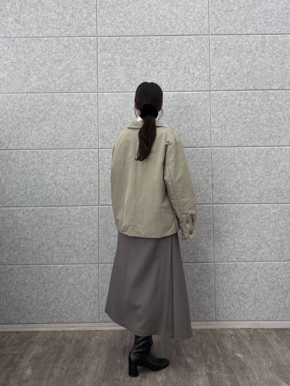 グレー系のスカート、ホワイト系のTシャツ/カットソー、グリーン系のブルゾンを着用したレディースの秋コーディネートの5枚目の写真