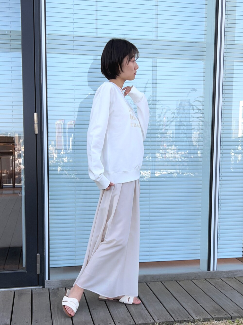 ベージュ系のスカート、ホワイト系のスウェットを着用したレディースの春コーディネートの4枚目の写真