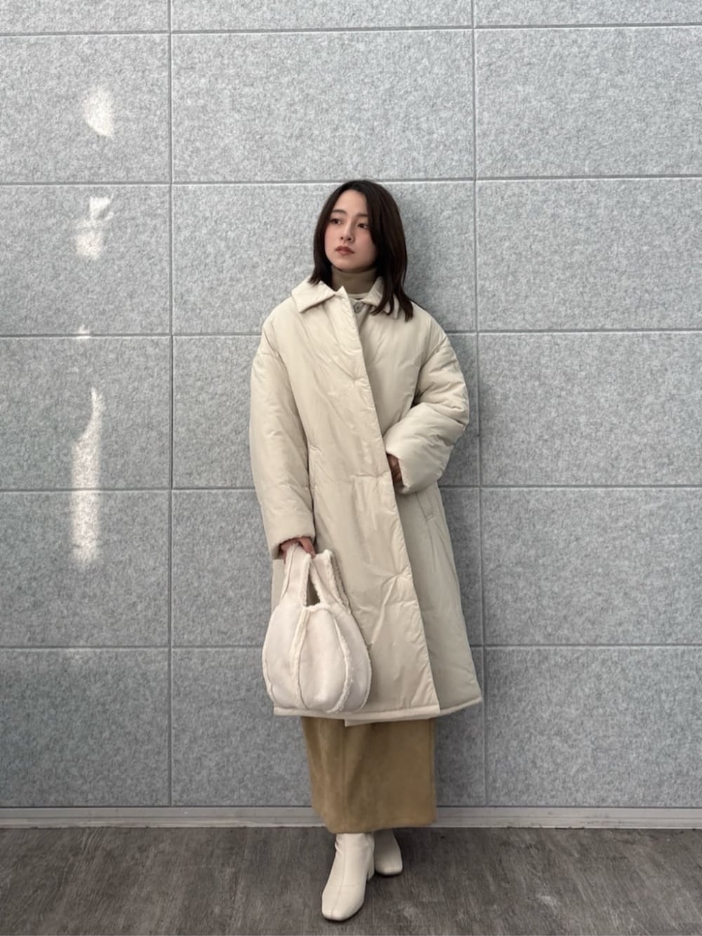 ベージュ系のその他アウター、ブラウン系のスカート、ベージュ系のニット/セーターを着用したレディースの冬コーディネートの3枚目の写真