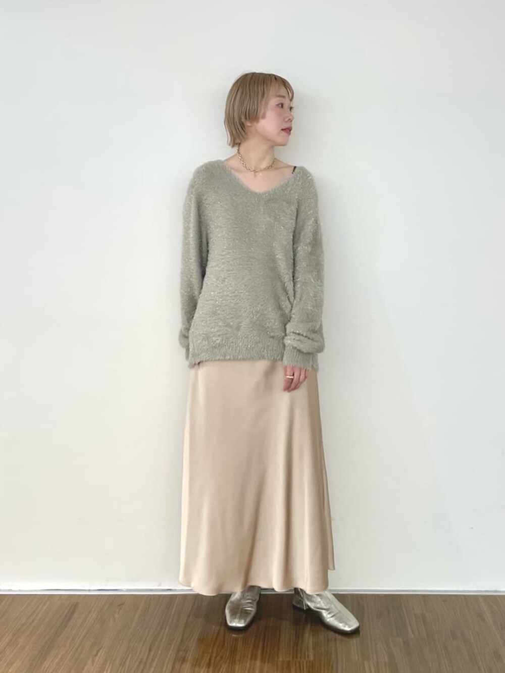 ベージュ系のスカート、グリーン系のニット/セーターを着用したレディースの冬コーディネートの2枚目の写真