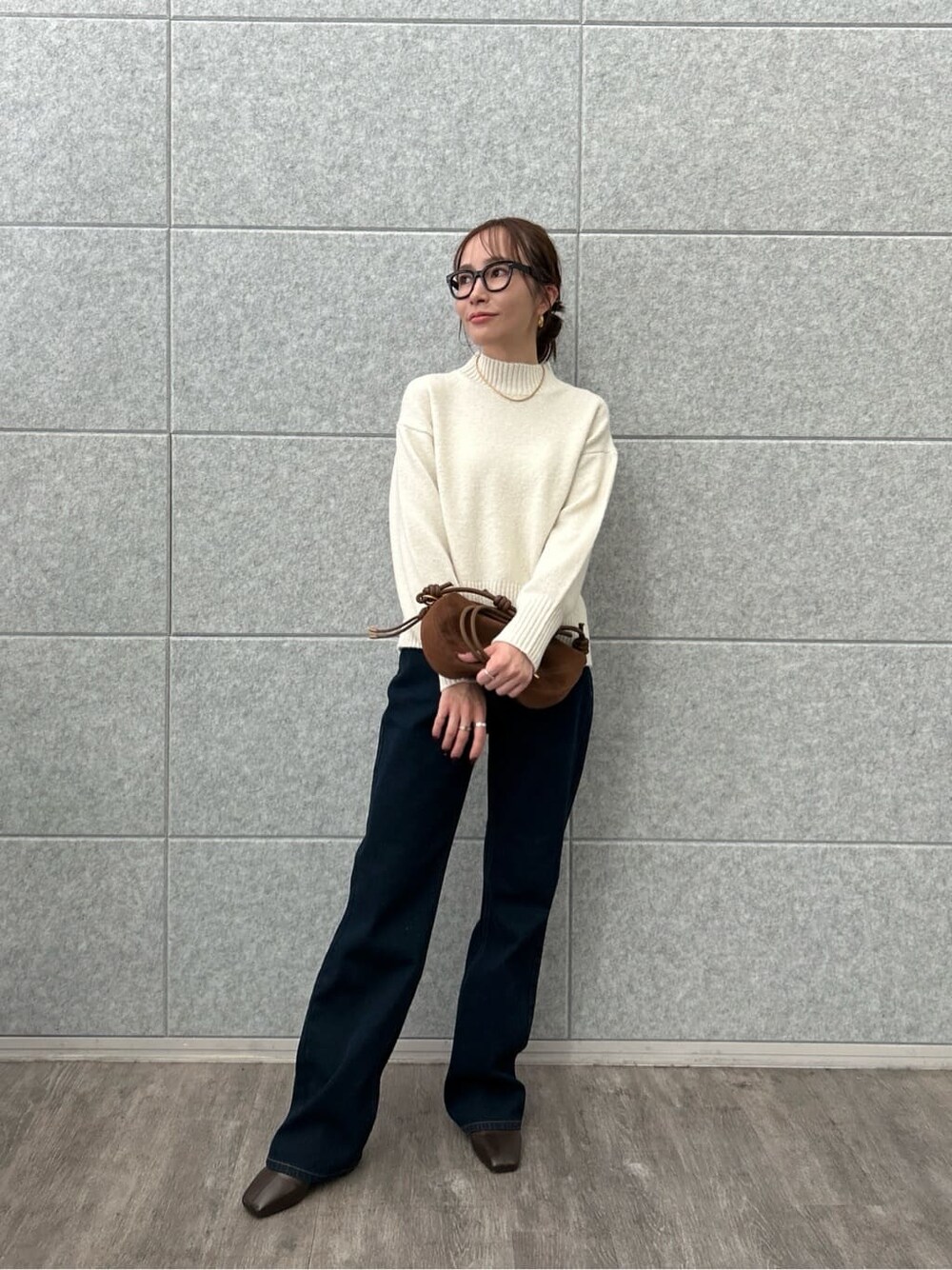 ホワイト系のニット/セーター、ブルー系のデニムパンツを着用したレディースの冬コーディネートの2枚目の写真