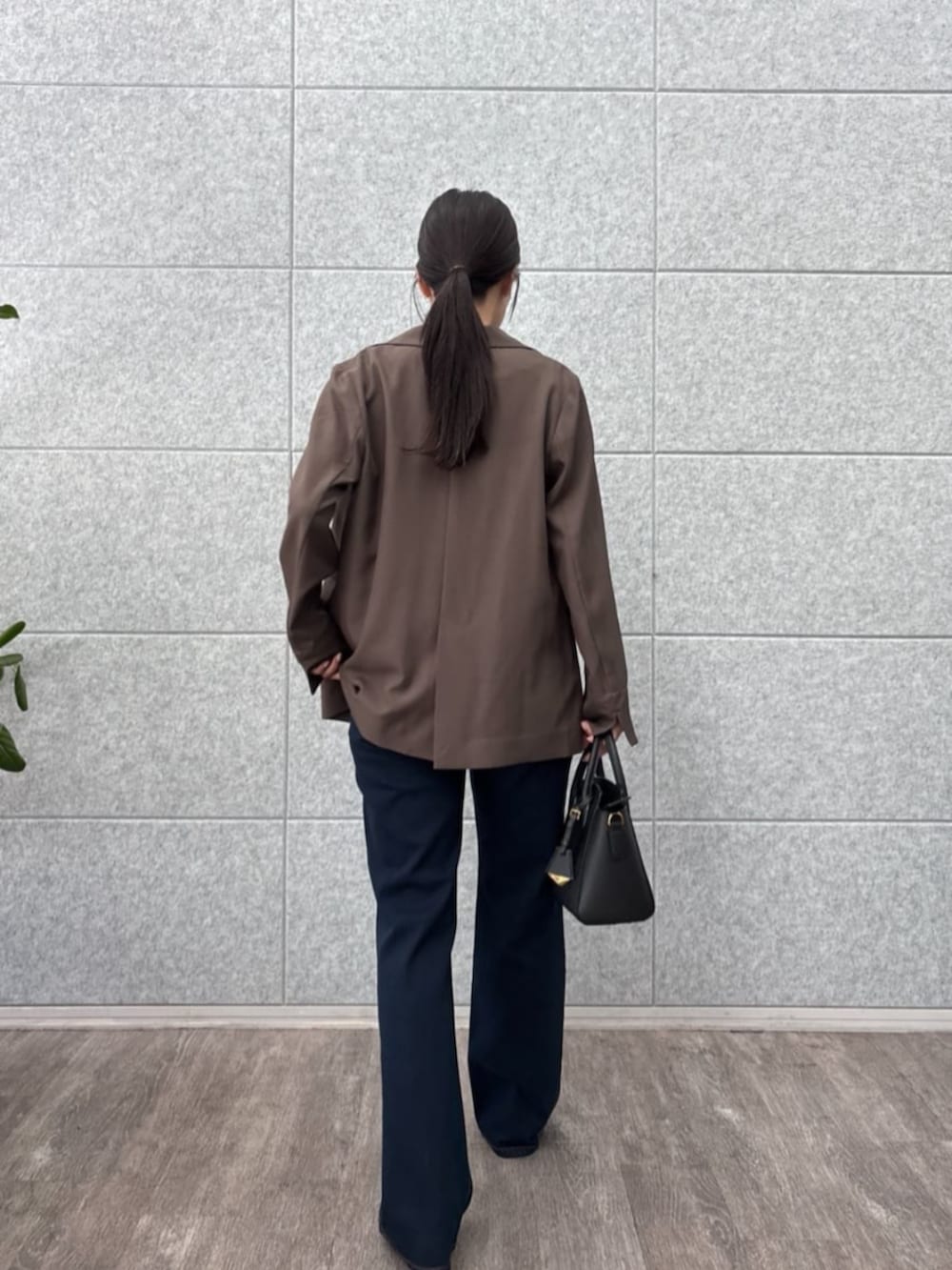 ブラウン系のテーラードジャケット、ブラック系のTシャツ/カットソー、ブルー系のデニムパンツを着用したレディースの秋コーディネートの6枚目の写真