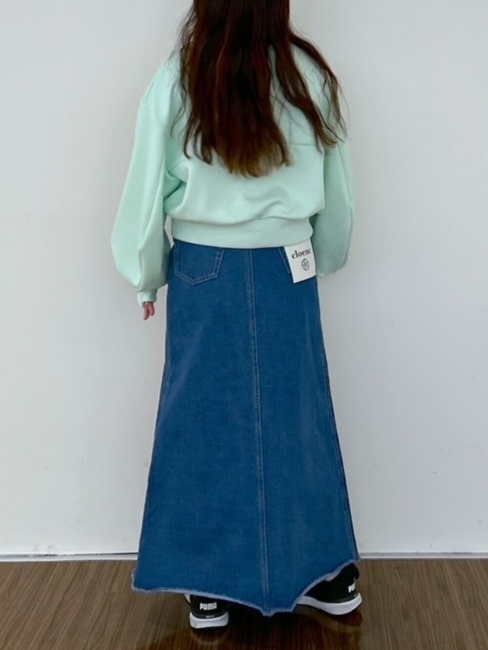 ブルー系のデニムスカート、グリーン系のスウェットを着用したレディースの春コーディネートの5枚目の写真