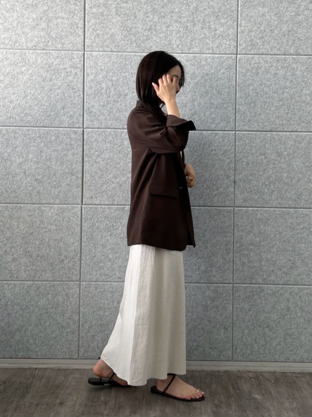 ホワイト系のスカート、ベージュ系のTシャツ/カットソー、ブラウン系のテーラードジャケットを着用したレディースの夏コーディネートの4枚目の写真